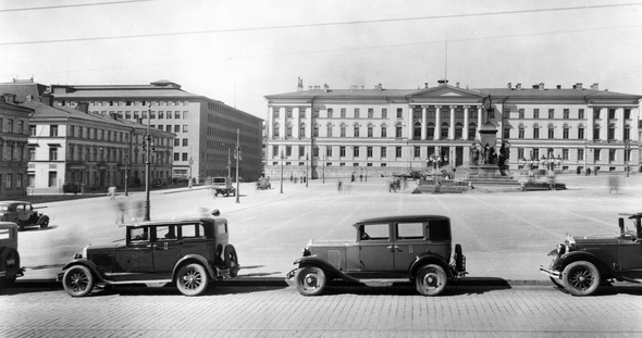 Mustat autot pysäköitynä aution senaatintorin reunalla. Taustalla näkyy vanha Helsingin yliopistorakennus.