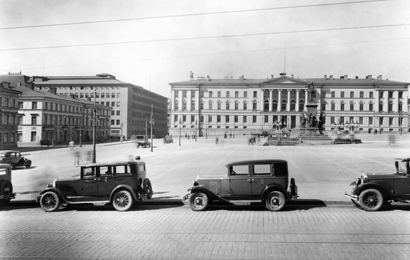 Mustat autot pysäköitynä aution senaatintorin reunalla. Taustalla näkyy vanha Helsingin yliopistorakennus.