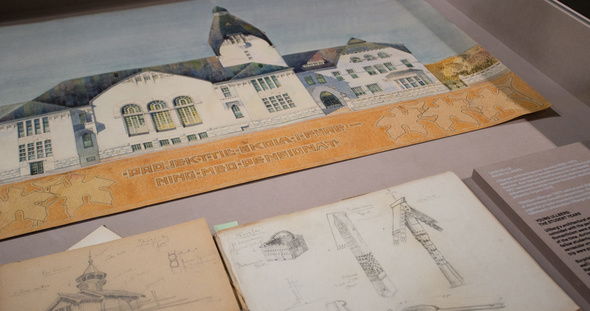 Uno Ullberg lähikuva näyttelyvitriinistä, jossa arkkitehdin koulutöitä