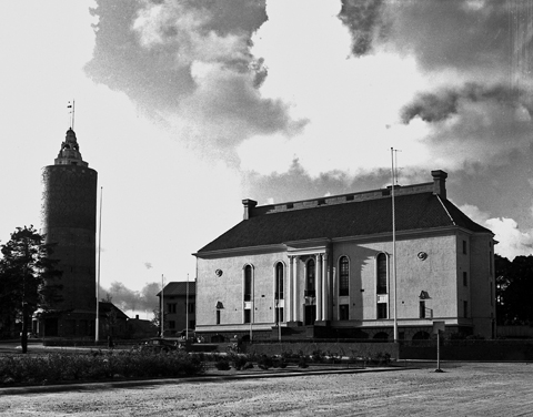 Eksteiröörikuva Keski-Pohjanmaan suojeluskuntalosta. Suojeluskuntatalo on uusklassistinen ja sen vieressä seisoo Kokkolan vanha vesitorni.