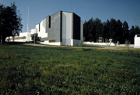 Eksteriöörivalokuva Alajärven kaupungintalosta. Kuvassa nurmikentän vierelle rinteeseen rakennettu rakennus.