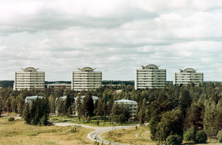 Tapiolan kerrostaloja. Metsän keskeltä kohoaa neljä toistensa kanssa identtistä kerrostaloa.