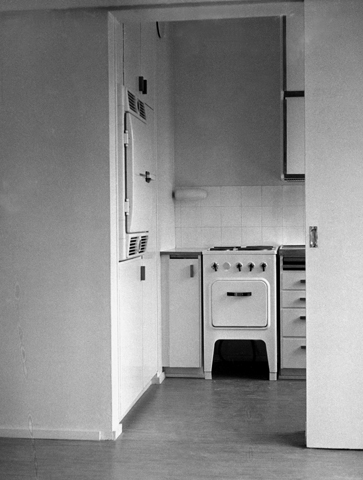 Interiöörikuva kerrostaloasunnon keittiöstä. Kuvassa vielä käyttämätön, vaalea keittiö liesineen ja jääkaappeineen.