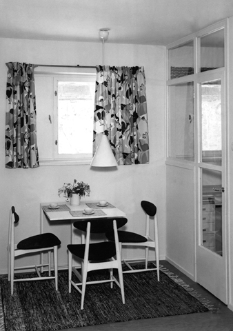 Interiöörikuva pienen kerrostaloasunnon ruokailutilasta. Kuvassa kolme tuolia pienen, katetun taittopöydän ympärillä.
