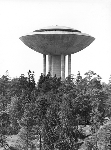 Eksteriöörivalokuva Haukilahden vesitornista. Etualalla on mäntymetsää, jonka keskeltä vesitorni kohoaa.